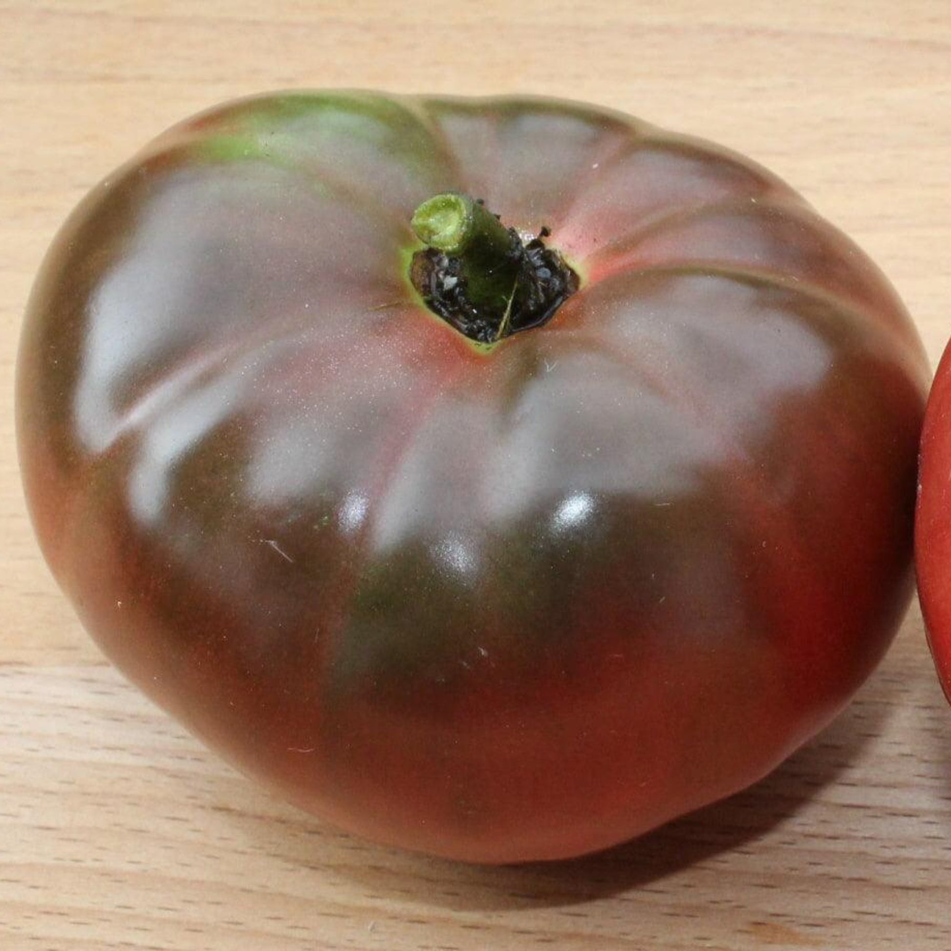 Dark purple Black Krim heirloom tomato on a wooden board