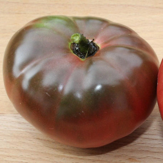 Dark purple Black Krim heirloom tomato on a wooden board