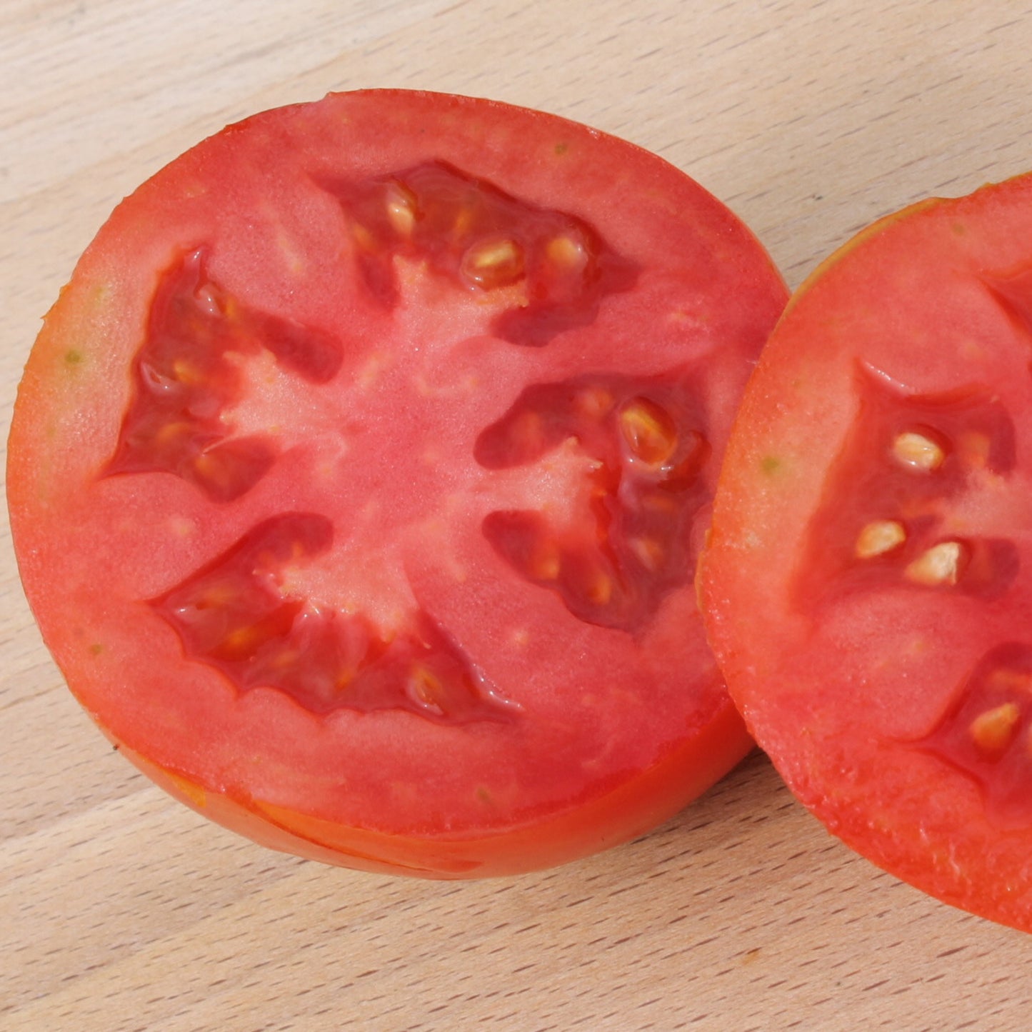 A few slices of Cannon Ball Tomato showing the deep red, dense, juicy flesh and smooth skin.