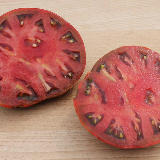 cherokee chocolate tomatoes sliced to show the interior with seeds.